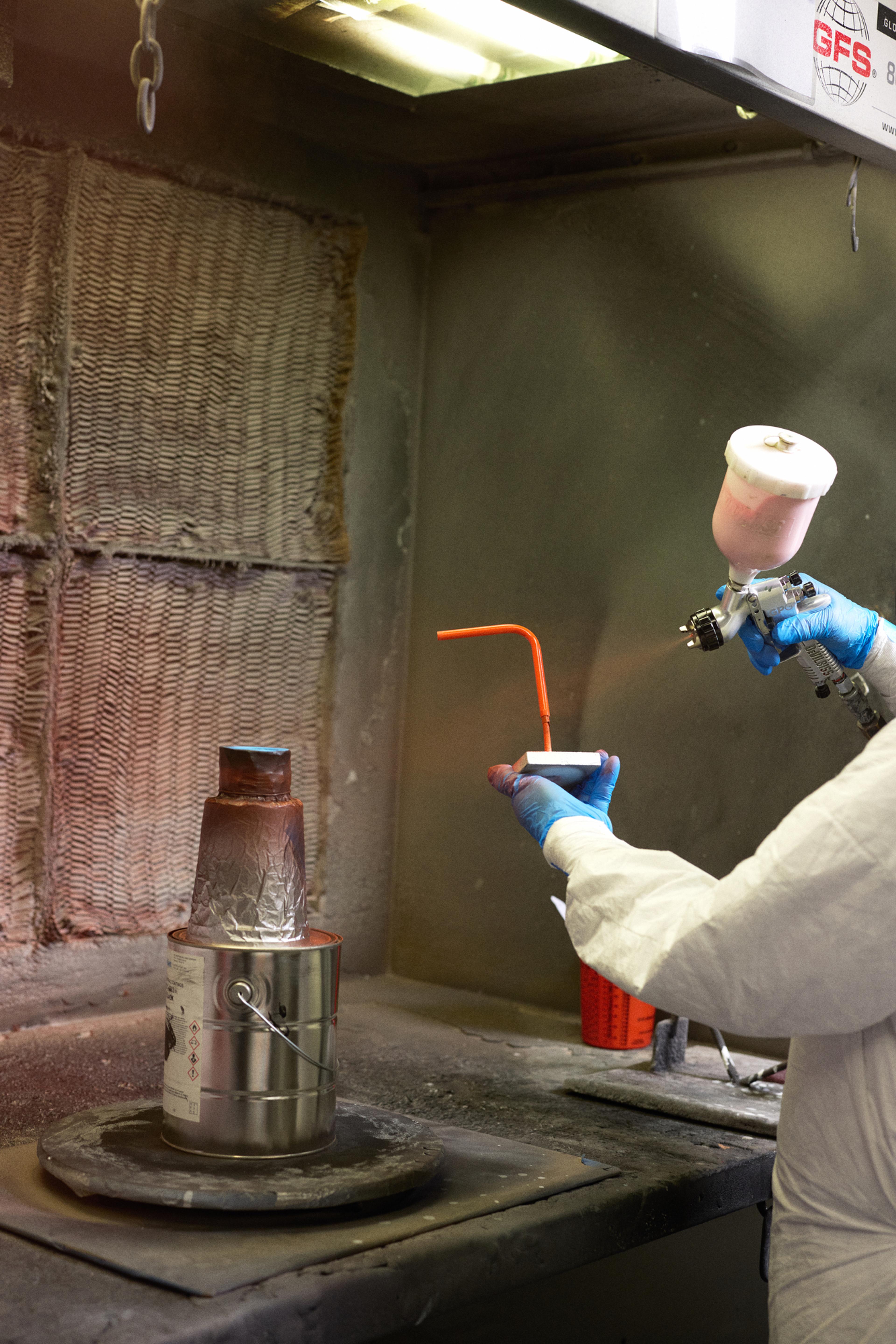 person spray painting light fixture