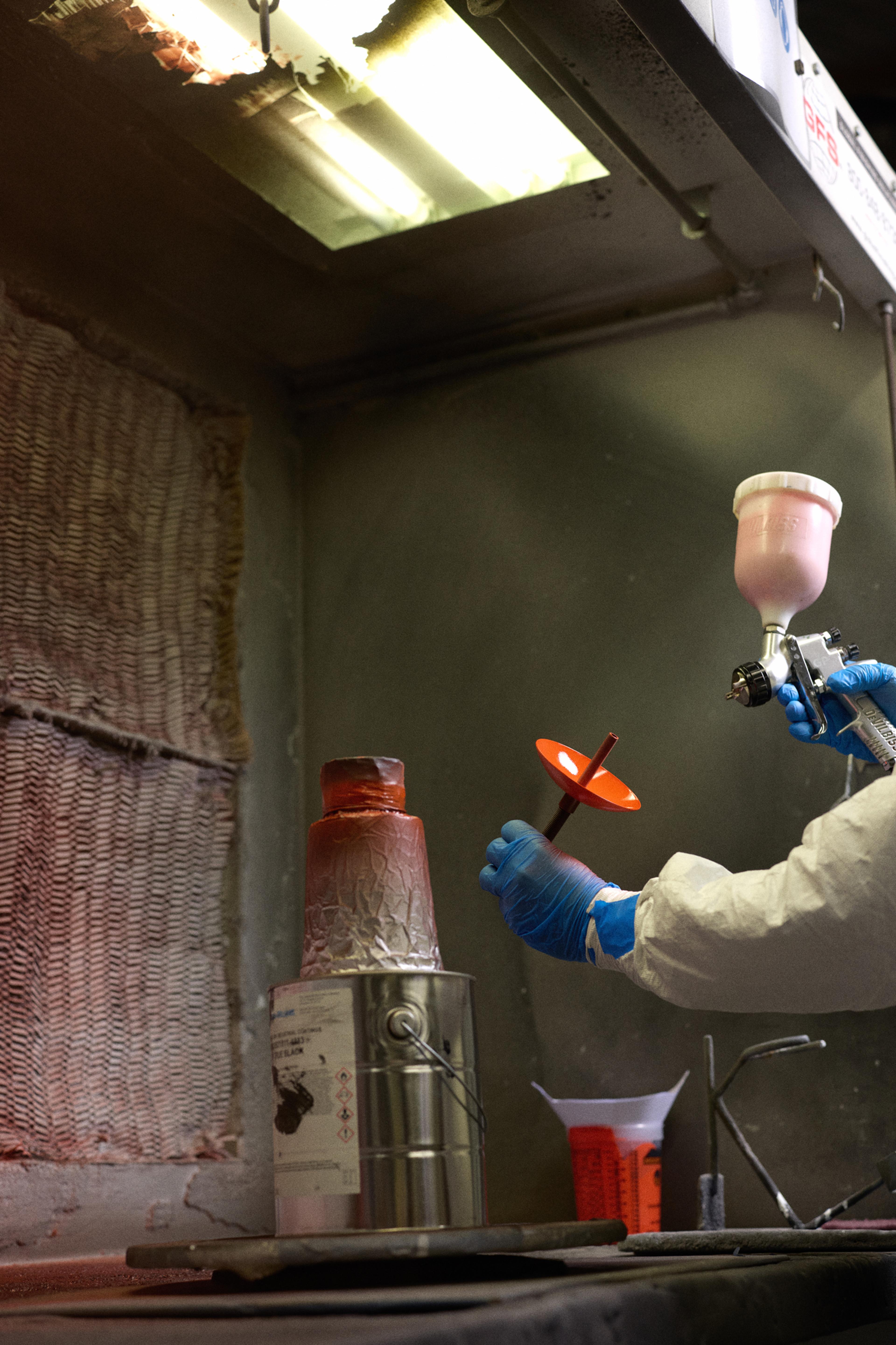person spray painting light fixture